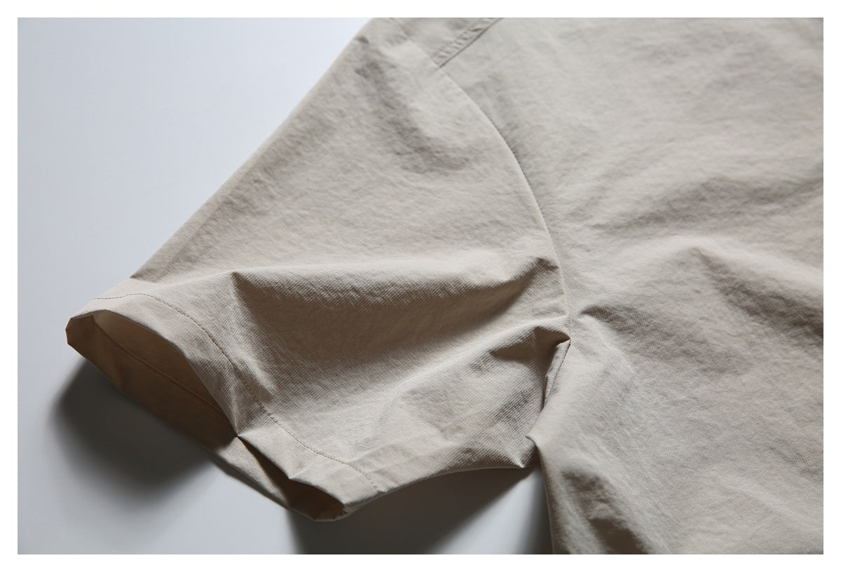 Close-up of the light beige shirt's short sleeve and stitched cuff.