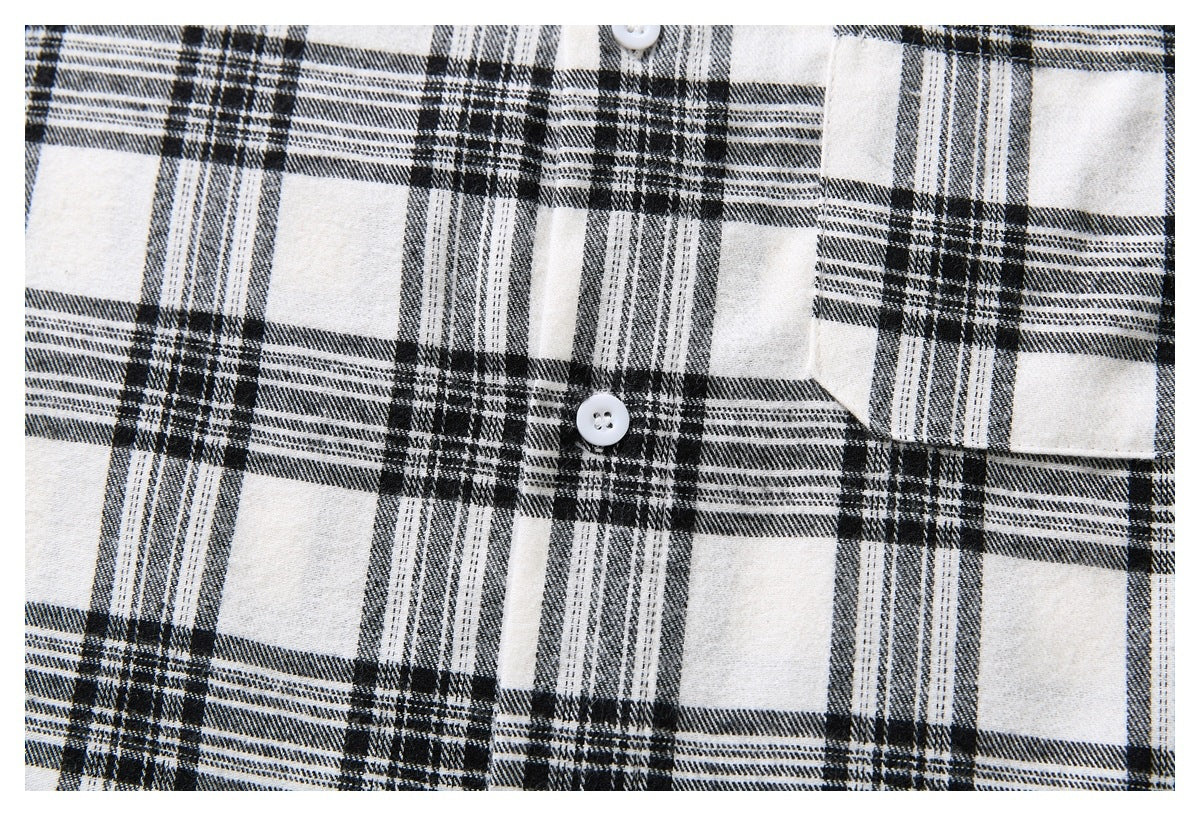 Close-up of the black-and-white plaid shirt front, showing its button placket and chest pocket.