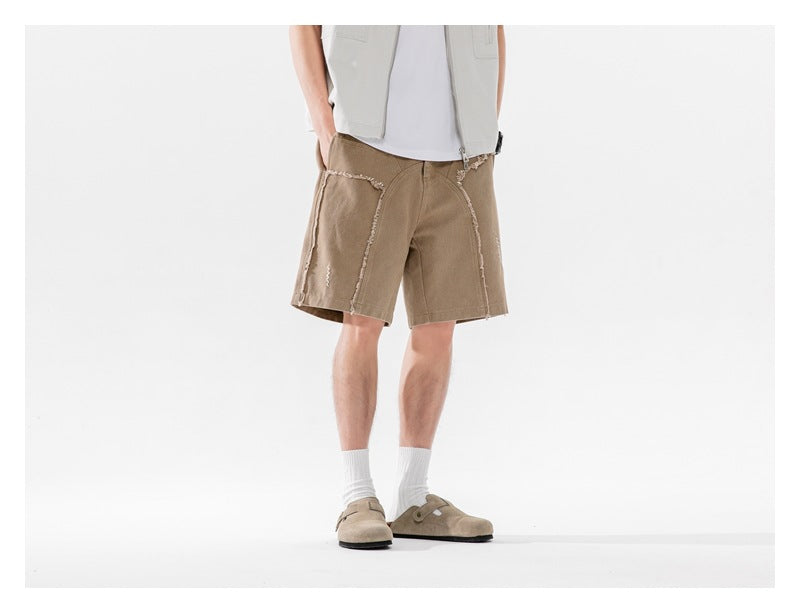 Model wearing tan knee-length shorts with frayed seam detailing, shown at a slight angle from the front.