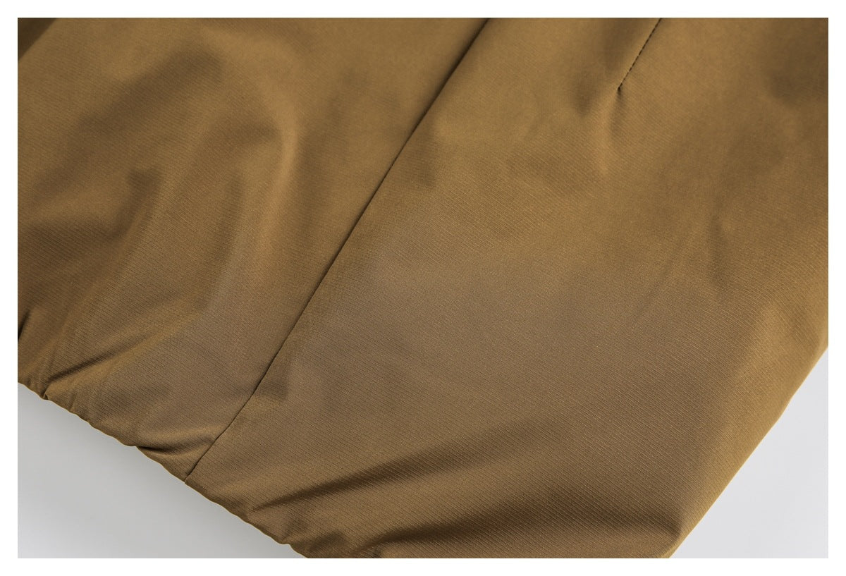 Close-up of a brown jacket panel seam and plain fabric.