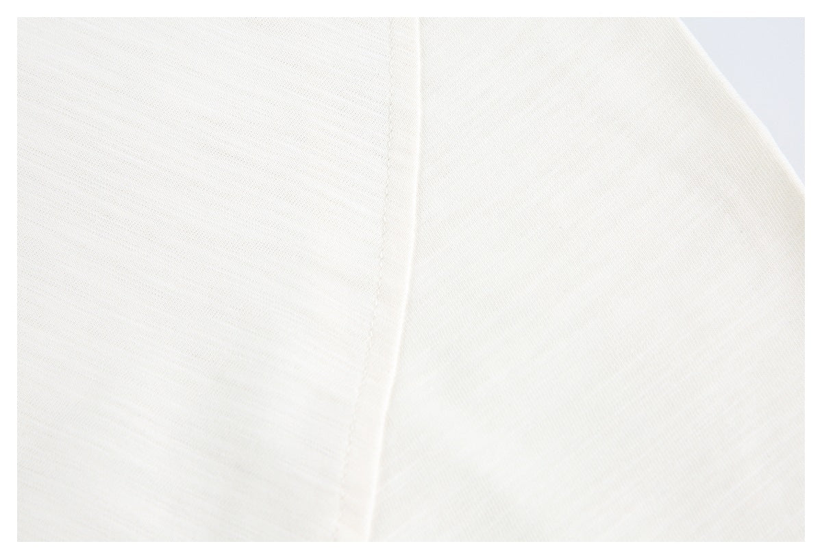 Close-up of off-white knit fabric showing a curved sleeve seam.