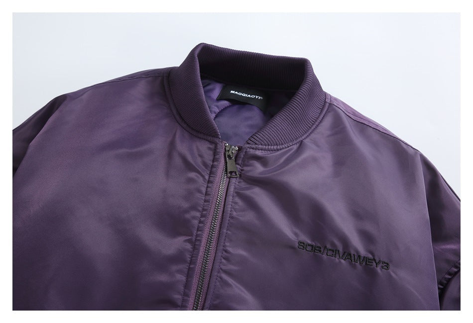 Close view of the purple bomber jacket's ribbed collar, front zipper, and black chest embroidery.
