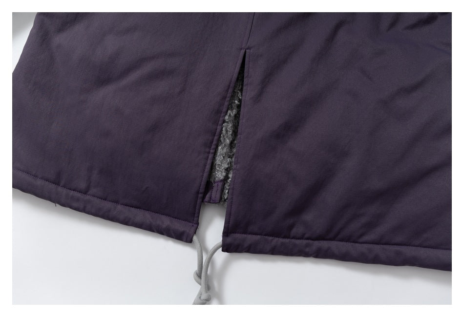 Close-up of a dark plum garment hem with a side slit, gray lining, and dangling drawcord.