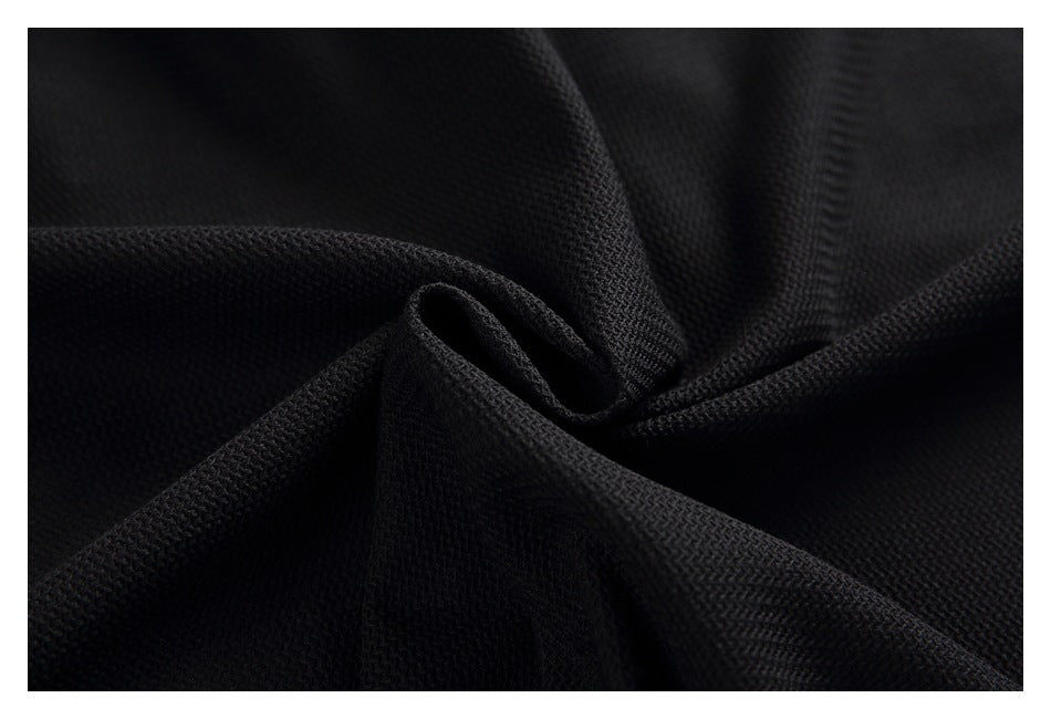 Close-up of the black garment's textured fabric gathered into soft folds.