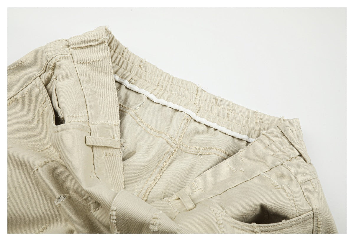 Close-up of beige trousers showing the inside waistband, belt loop, pocket opening, and stitched seams.