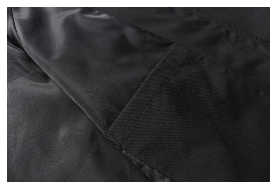 Close-up of a black jacket sleeve and stitched cuff area beside a zipper.