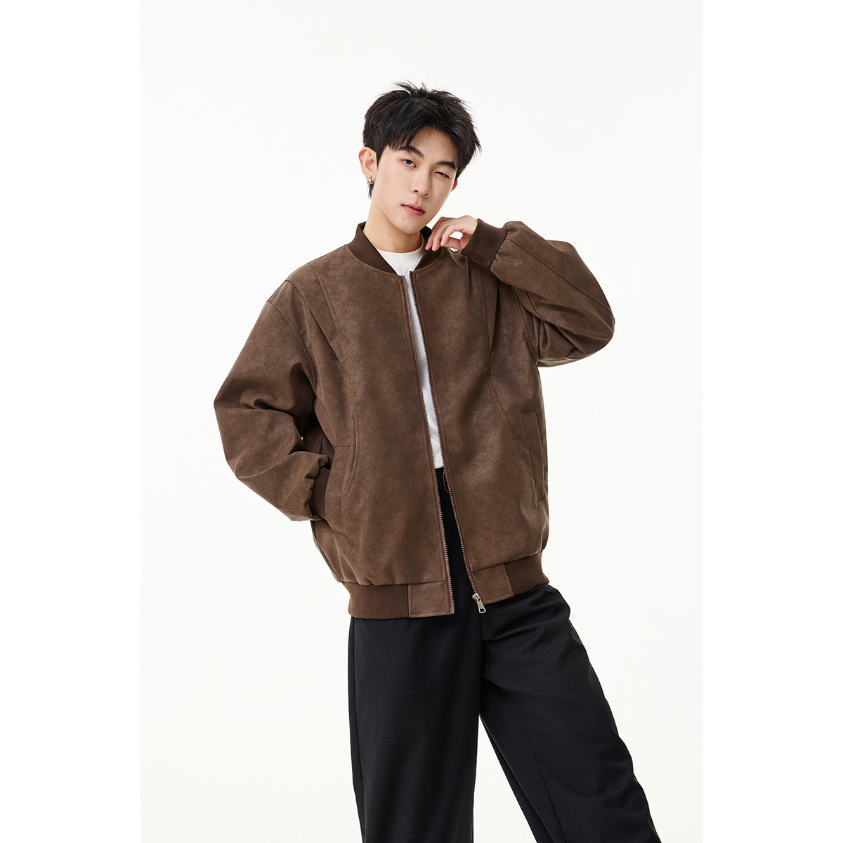 Model wearing a brown zip-front bomber jacket with ribbed trim and front pockets.