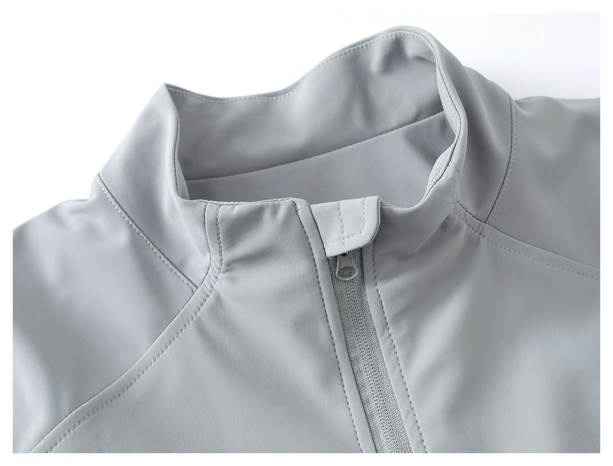 Close-up of a light gray jacket's stand collar and front zipper with a protective flap.