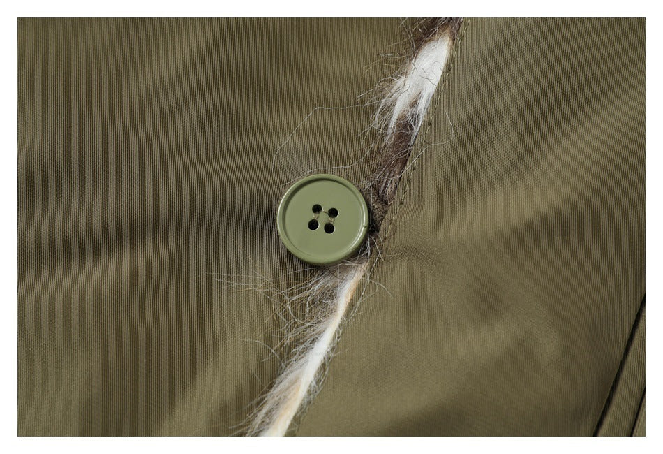 Close-up of a four-hole olive button beside the jacket’s fur-trimmed edge.
