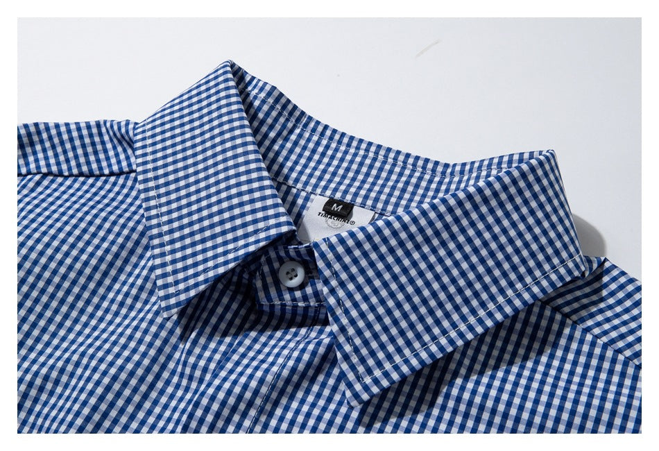 Close-up of a blue-and-white gingham shirt collar and top button.