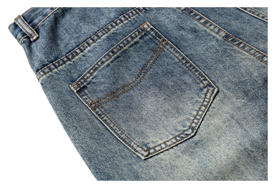Close-up of a back pocket on faded blue jeans with contrasting double-row stitching.