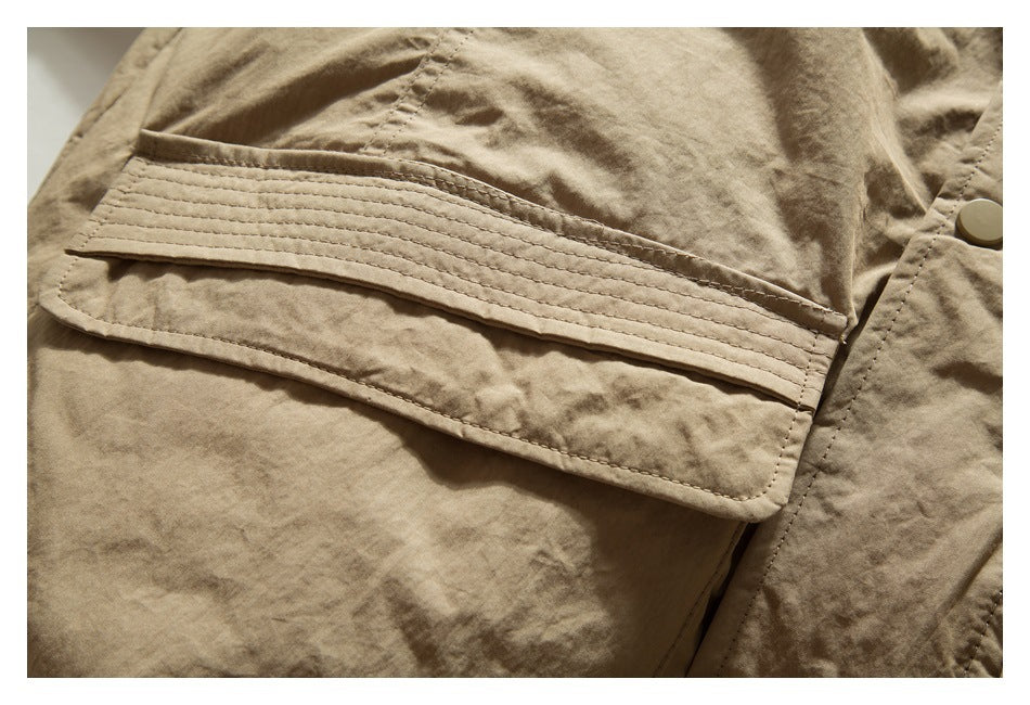 Close-up of a tan jacket flap pocket with several parallel rows of stitching.