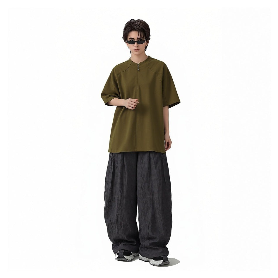 Model wearing olive-brown short-sleeve zip stand-collar T-shirt with wide dark gray pants