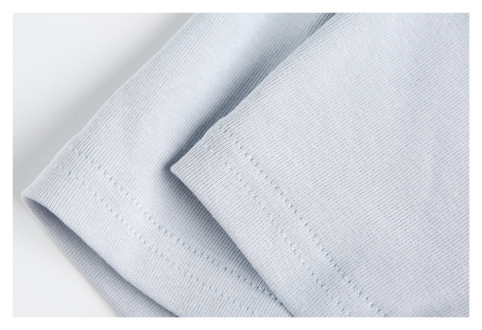 Close-up of a pale blue garment hem with parallel rows of stitching.