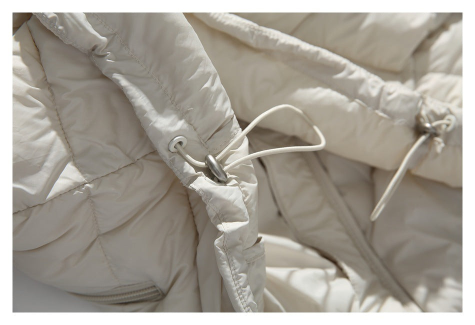 Close-up of ivory jacket panels with drawcords, toggles and a pocket zipper.