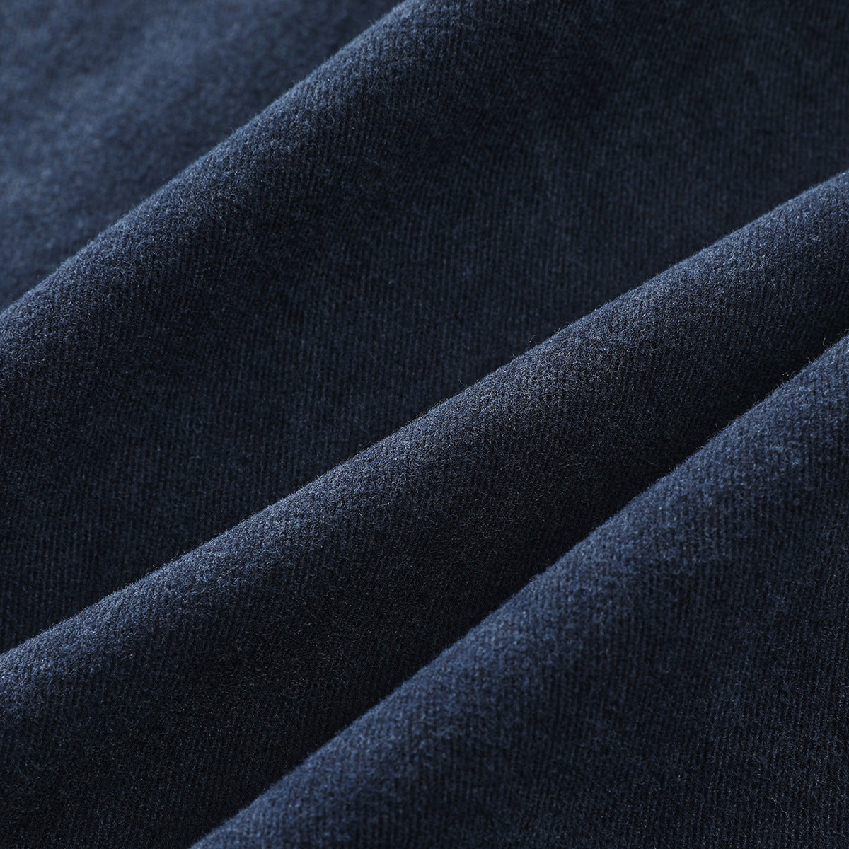 Extreme close-up of dark indigo fabric folds showing its woven surface and texture.