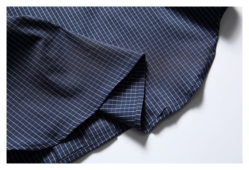 Close-up of the navy check shirt hem and folded edge stitching.