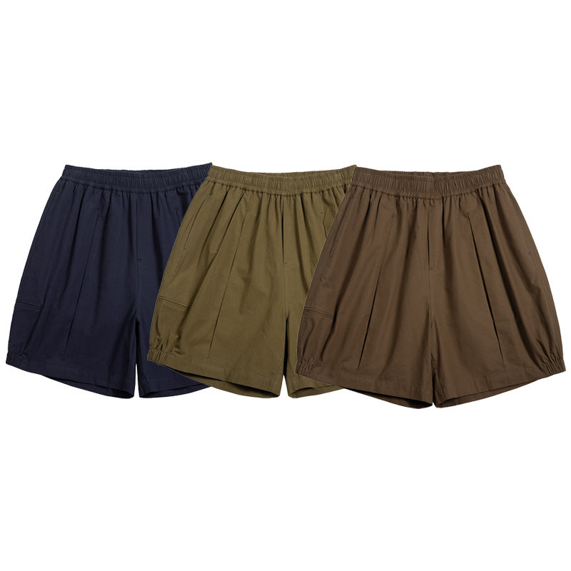 Three loose elastic-waist shorts shown together in navy, olive green, and brown.