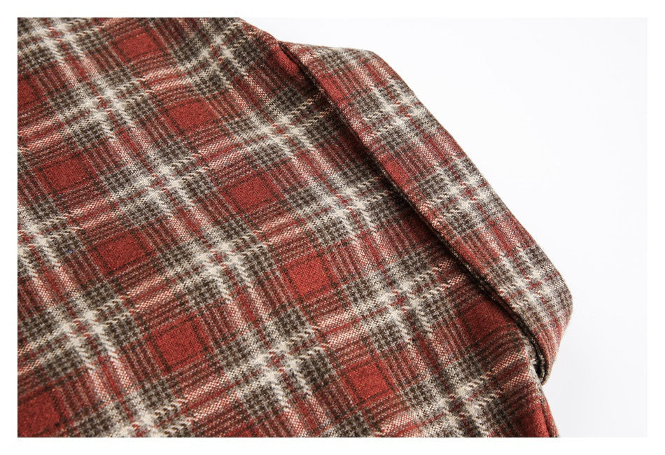 Close-up of the plaid shirt shoulder and sleeve seam in red, brown, and cream checks.