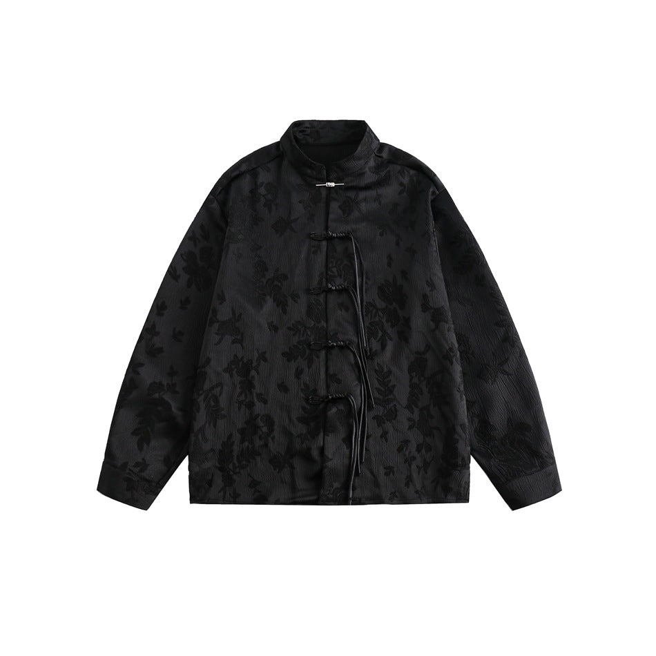 Black floral jacquard stand-collar shirt with knotted frog buttons and tassel cords, flat lay front view