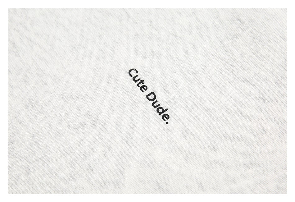 Close-up of the black words “Cute Dude.” printed on light heather-gray sweatshirt fabric.