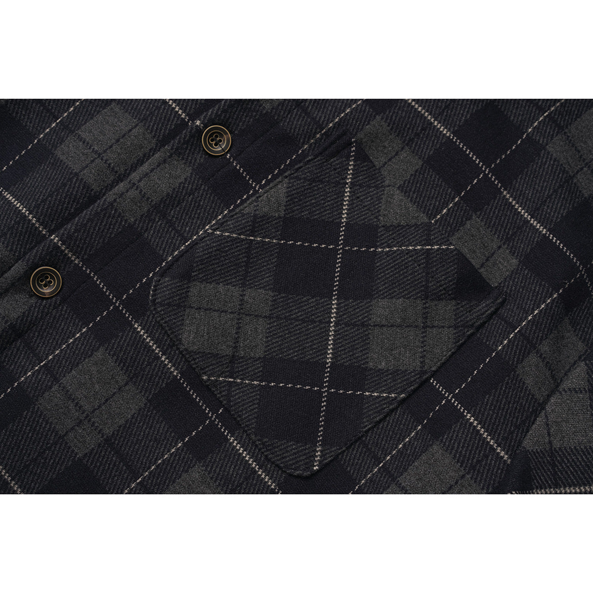 Close-up of a dark plaid shirt's single chest pocket and two buttons.
