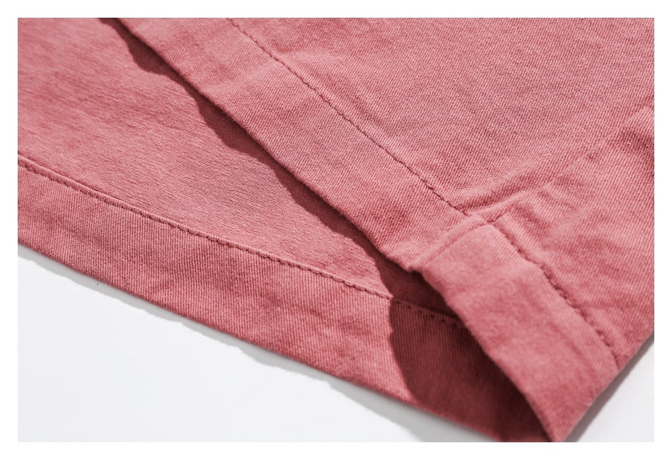 Close-up of dusty rose fabric showing a stitched seam and folded hem.