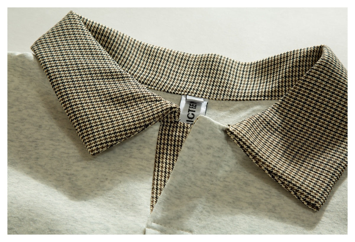 Close-up of a light gray polo shirt's brown, black, and cream patterned collar and partially visible neck label.