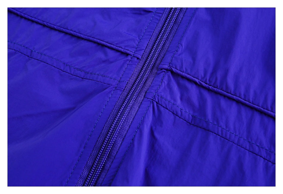Close-up of the blue jacket's front zipper and stitched panel seams.