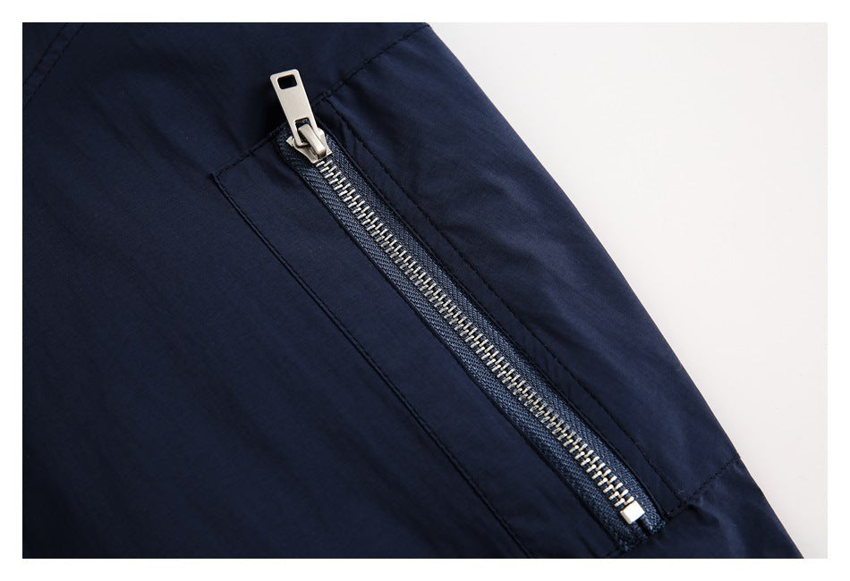 Close-up of a silver zipper pocket on the navy jacket sleeve.