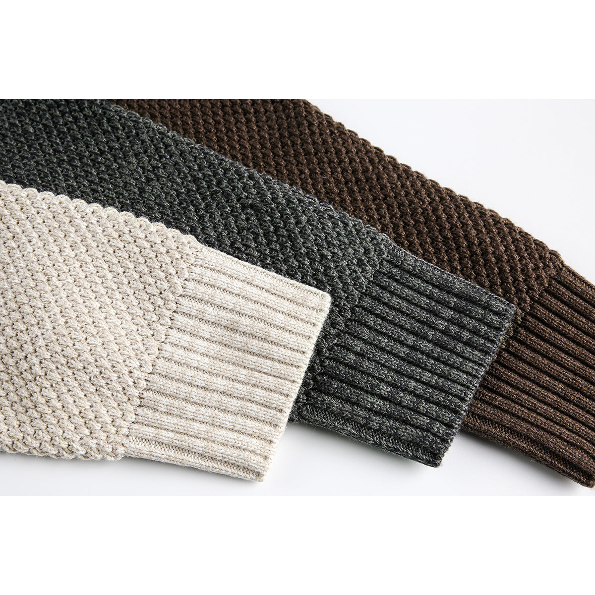 Close-up of sweater sleeves and ribbed cuffs in oatmeal, charcoal gray and dark brown.