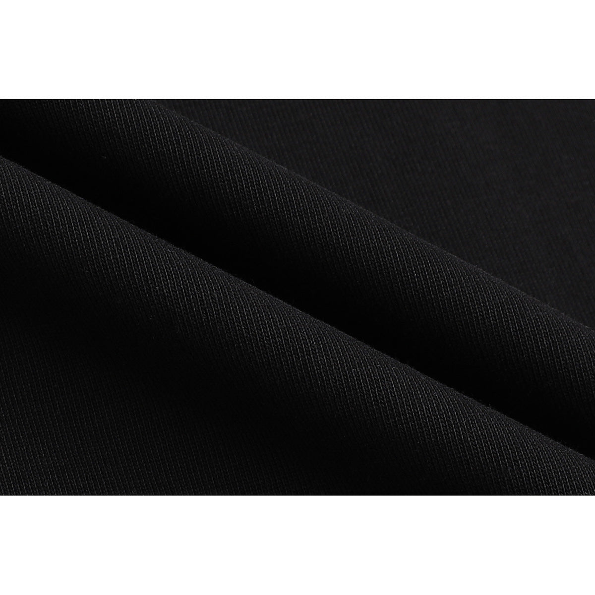 Extreme close-up of black fabric folded to show its fine, ribbed-looking surface texture.