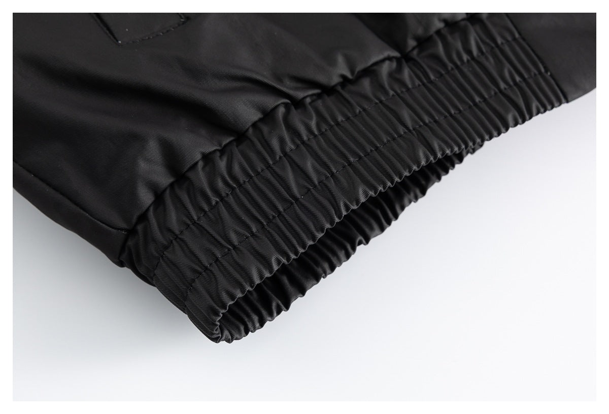Close-up of a black garment hem with a gathered elastic cuff and visible stitching.