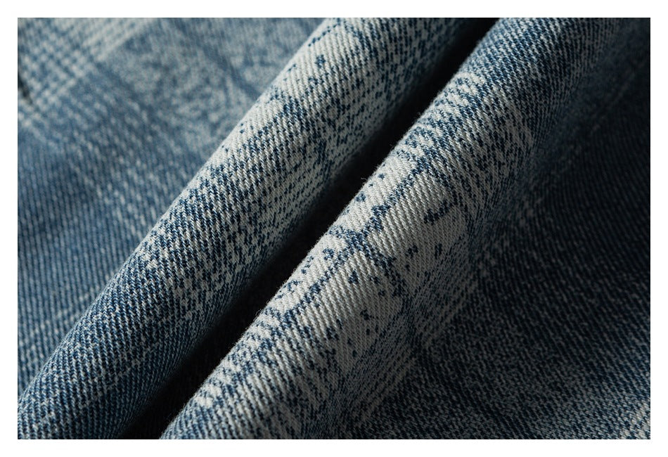 Close-up of folded blue-and-white patterned denim showing its diagonal weave and texture.