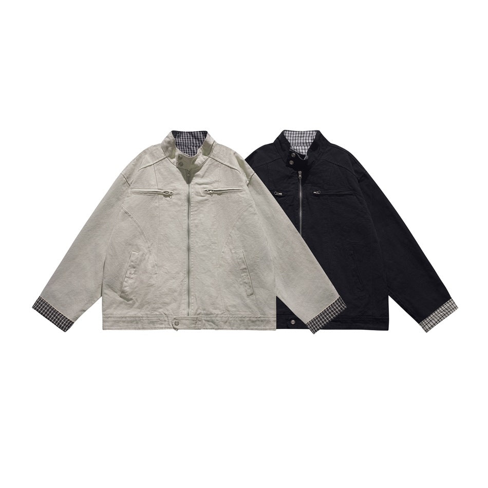 Front view of light gray and black jackets with stand collars, zip pockets, and plaid trim.