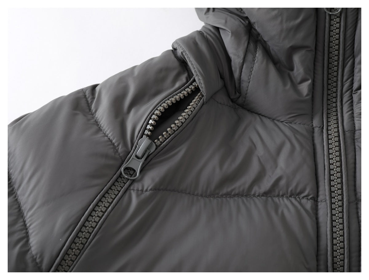 Close-up of a diagonal zippered pocket on a dark gray quilted jacket.