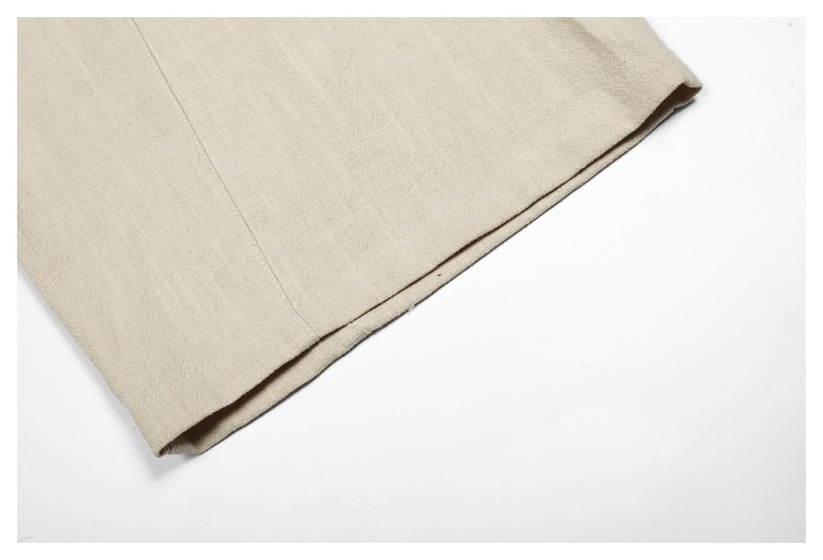 Close-up of the beige trouser leg showing its folded hem and stitching.