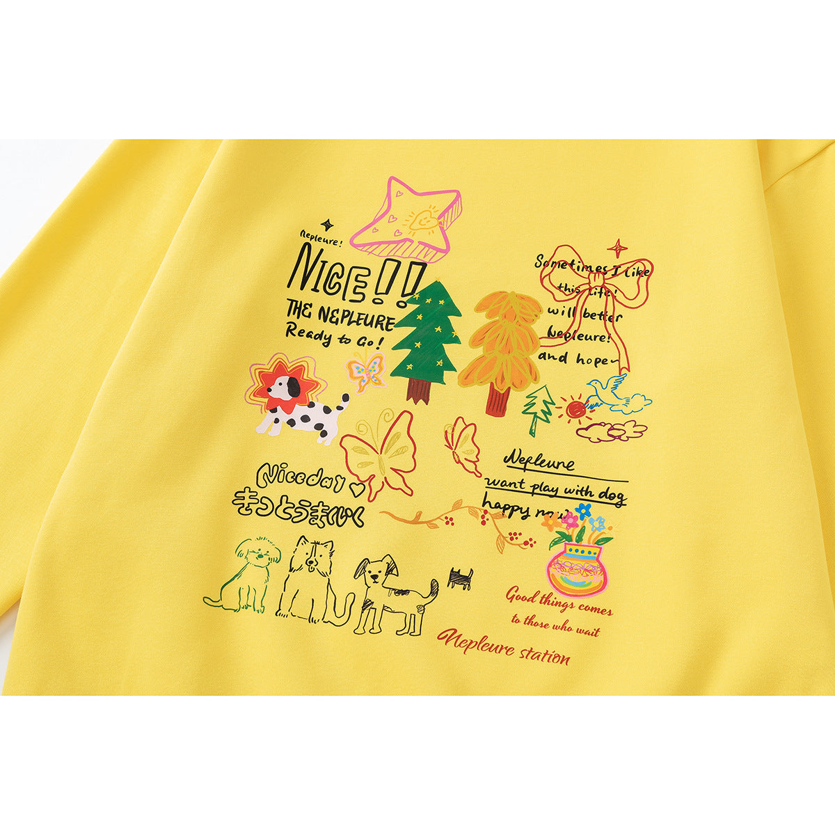 Close-up of a yellow sweatshirt with colorful dog, flower and tree illustrations, handwritten English and Japanese lettering.