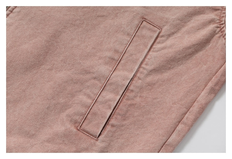 Close-up of a slanted welt pocket on dusty rose fabric.