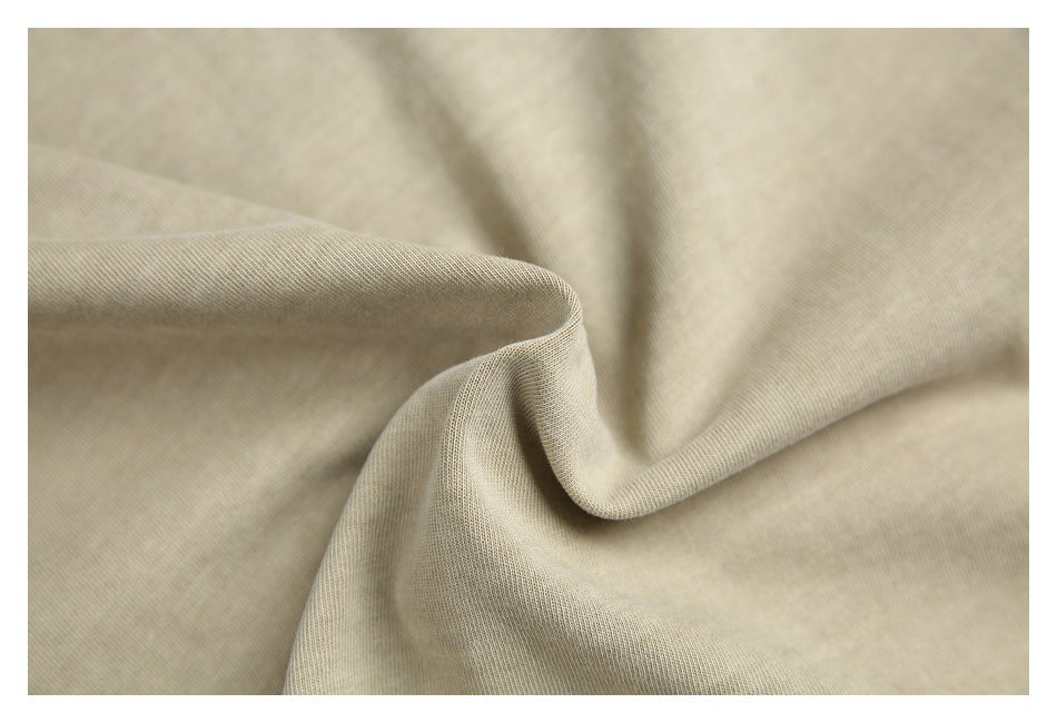 Close-up of softly folded beige fabric showing its fine, subtle texture.