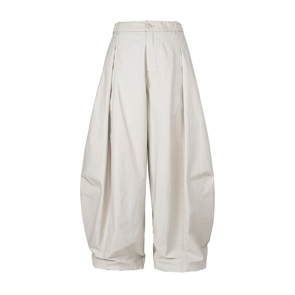 Off-white wide-leg balloon pants with elastic waistband, button closure, front pleats and cuffed hems, front view