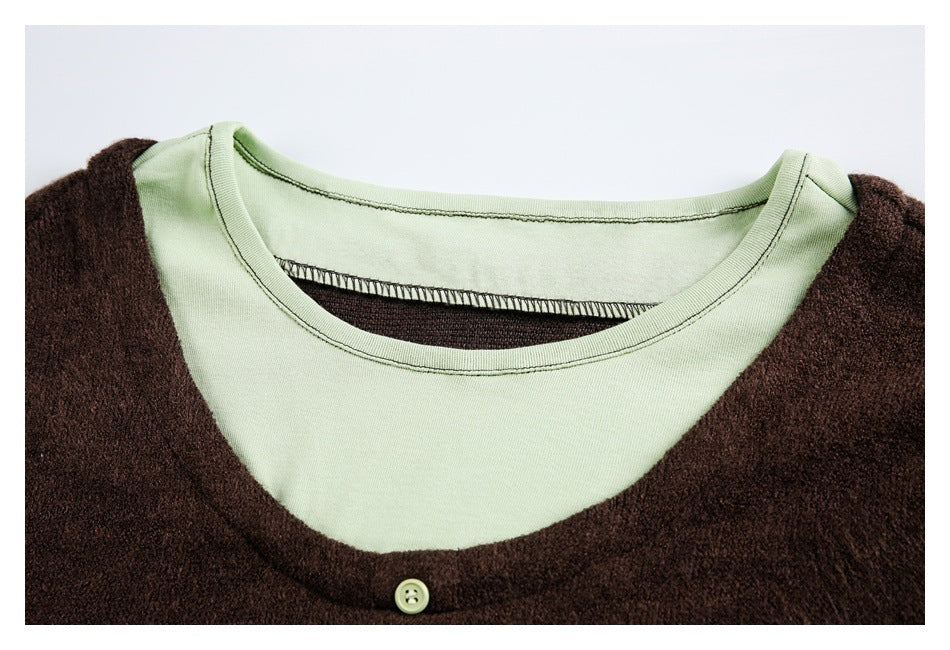 Close-up of a dark brown fuzzy top layered over a pale green crew-neck shirt, with one pale button visible.