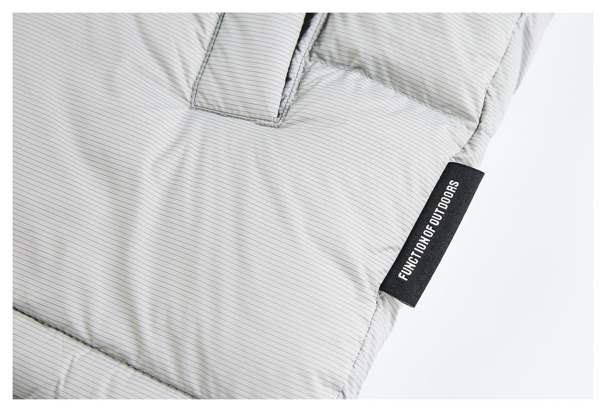 Close-up of light gray pinstriped fabric with a black “FUNCTION OF OUTDOORS” garment tag.