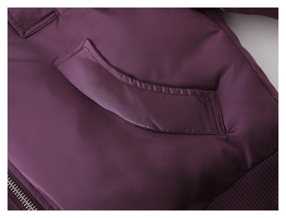 Close-up of a curved pocket on the plum-purple jacket, with stitching and part of the ribbed hem visible.