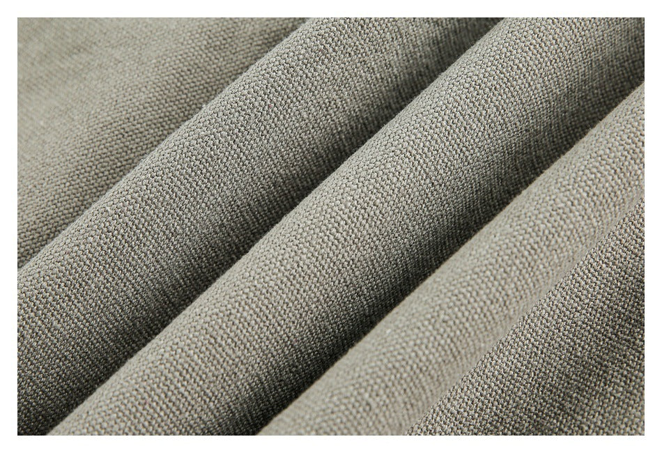 Close-up of gray-beige woven fabric arranged in soft diagonal folds.