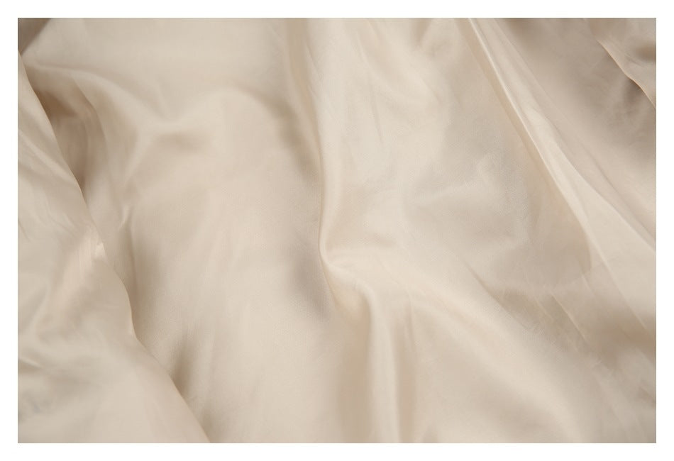 Close-up of the smooth pale lining inside a beige jacket.