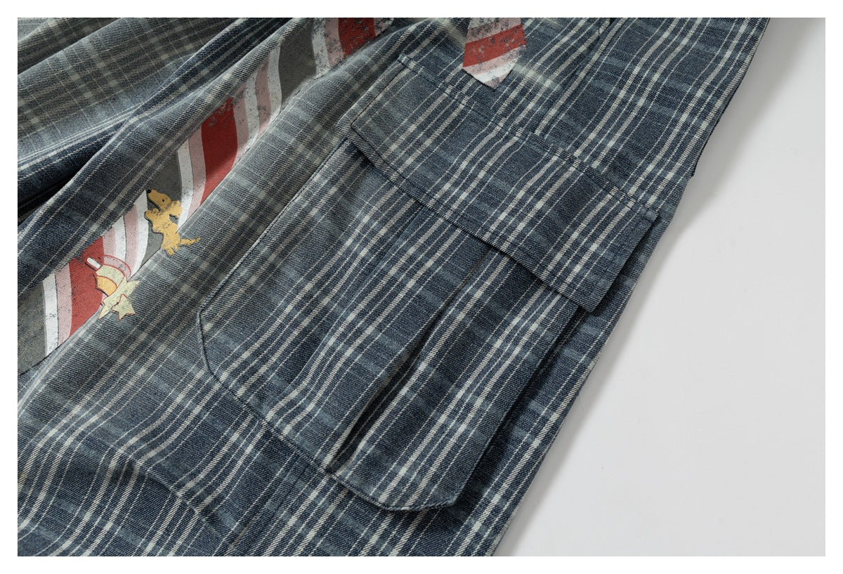 Close-up of a blue-gray plaid garment pocket with part of a red, white, and yellow printed design visible.