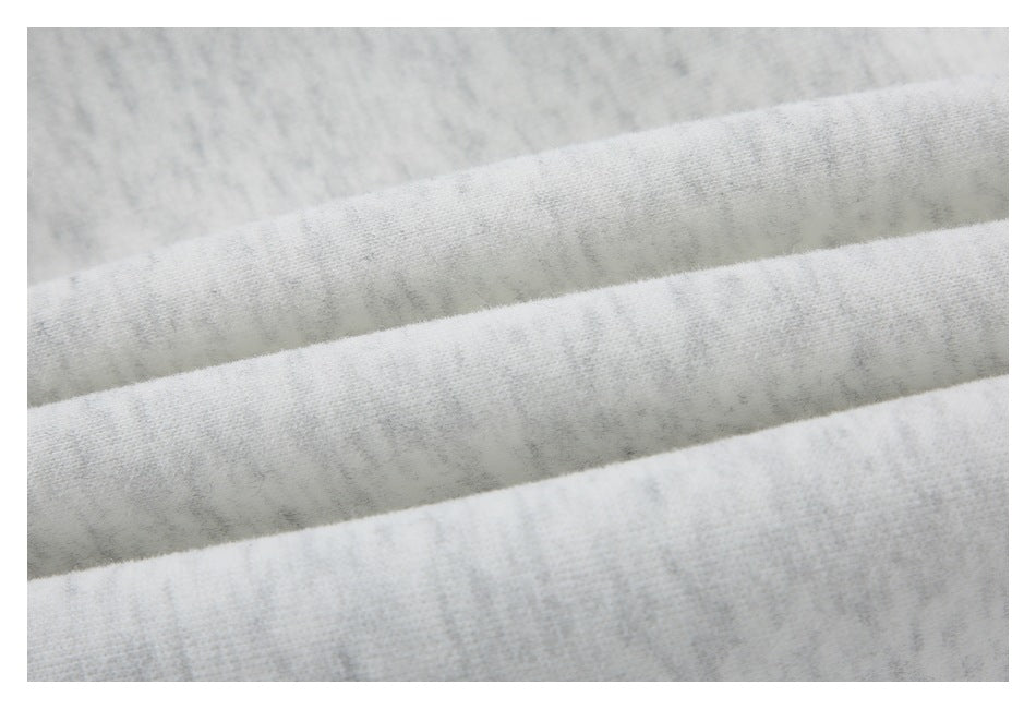 Macro view of the light gray marled fabric folded into parallel ridges.