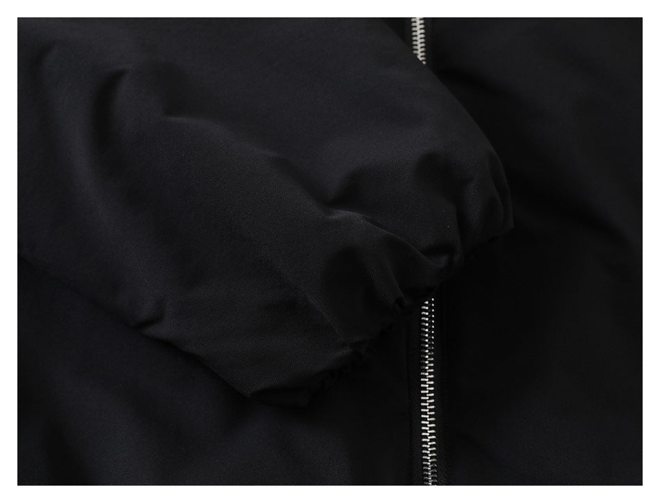 Close-up of black fabric with a vertical silver zipper.