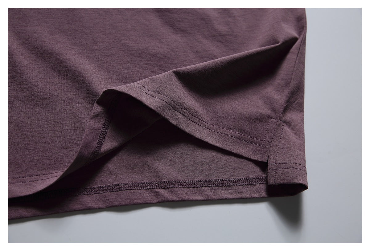 Close-up of the plum T-shirt's folded bottom hem, showing the overlock stitching underneath.